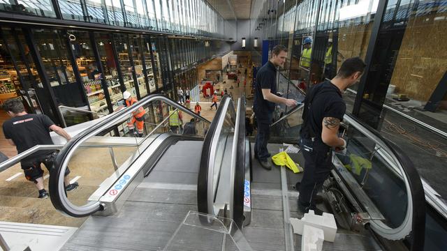 Des ouvriers finissant les travaux de la nouvelle allée centrale de la gare Cornavin. [Martial Trezzini]