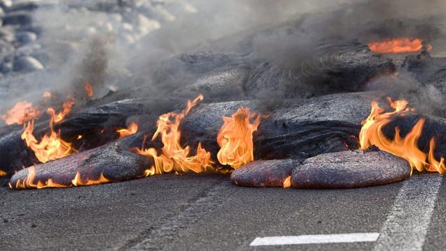 Le flot de lave avance de 9 à 14 mètres par heure à Hawaï et pourrait couper l'une des principales routes de l'île (ici en 2008 la lave du Kilauea avait déjà envahi la route). [EPA/BRUCE OMORI]