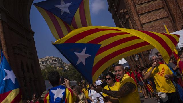 Une foule rouge et or réclame un référendum sur l'indépendance catalane [AP Photo/Emilio Morenatti]