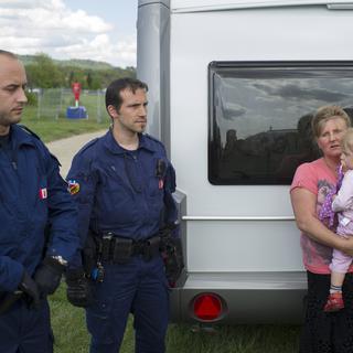 Une femme et son enfant lors de l'expulsion par la police des gens du voyage le jeudi 24 avril 2014 à Berne. [Gian Ehrenzeller]