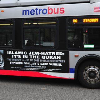 UNITED STATES, Washington : A Metro bus, featuring a controversial ad, drives on a street in Washington, DC on May 21, 2014. Bus-ads linking "Islamic Jew-hatred" Islam with Adolf Hitler are out on the streets of Washington, and the US capital's mass transit authority said May 20 it is legally powerless to ban them.The elongated broadsides on 20 Metro buses feature a photo of the Nazi German dictator Adolf Hitler in conversation with "his staunch ally" Haj Amin al-Husseini, grand mufti of Jerusalem during World War II. "Islamic Jew-hatred: It's in the Quran. Two-thirds of all US aid goes to Islamic countries. Stop racism. End all aid to Islamic countries," the ad states, over a fine-print disclaimer from the Metro transit authority. The ads, which are to run until mid-June, were placed by the American Freedom Defense Initiative (AFDI), which aims to "raise awareness of the depredations of Islamic supremacism," according to its website. AFP PHOTO / Karen BLEIER [Karen Bleier]