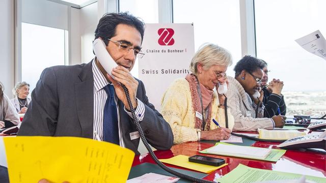 Les personnalités suisses soutiennent souvent activement les campagnes de la Chaîne du Bonheur. Ici, le présentateur du journal télévisé de la RTS, Darius Rochebin, qui receueille des promesses de dons au téléphone. [Yannick Bailly]