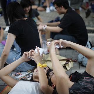Deux étudiants pro-démocratie utilisant leur smartphone durant une manifestation à Hong-Kong. [Wong Maye-E]