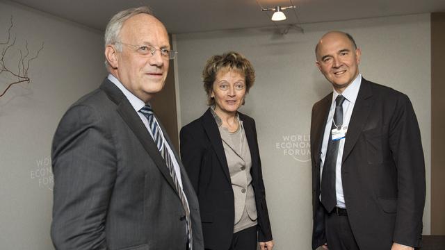 Johann Schneider-Ammann, Eveline Widmer-Schlumpf et Pierre Moscovici, ce vendredi à Davos. [Jean-Christophe Bott]