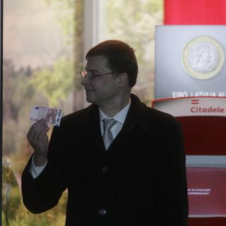 Le Premier ministre letton Valdis Dombrovskis tient un euro pour symboliser l'entrée de la Lettonie dans la zone euro. [EPA/Valda Kalinina]