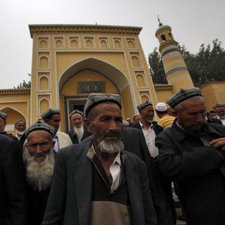 Des Ouïghoures devant la mosquée où a été tué l'imam. [EPA/HOW HWEE YOUNG]