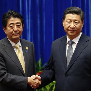Poignée de mains entre les leaders japonais et chinois à Pékin. [Kim Kyung-Hoon/pool]