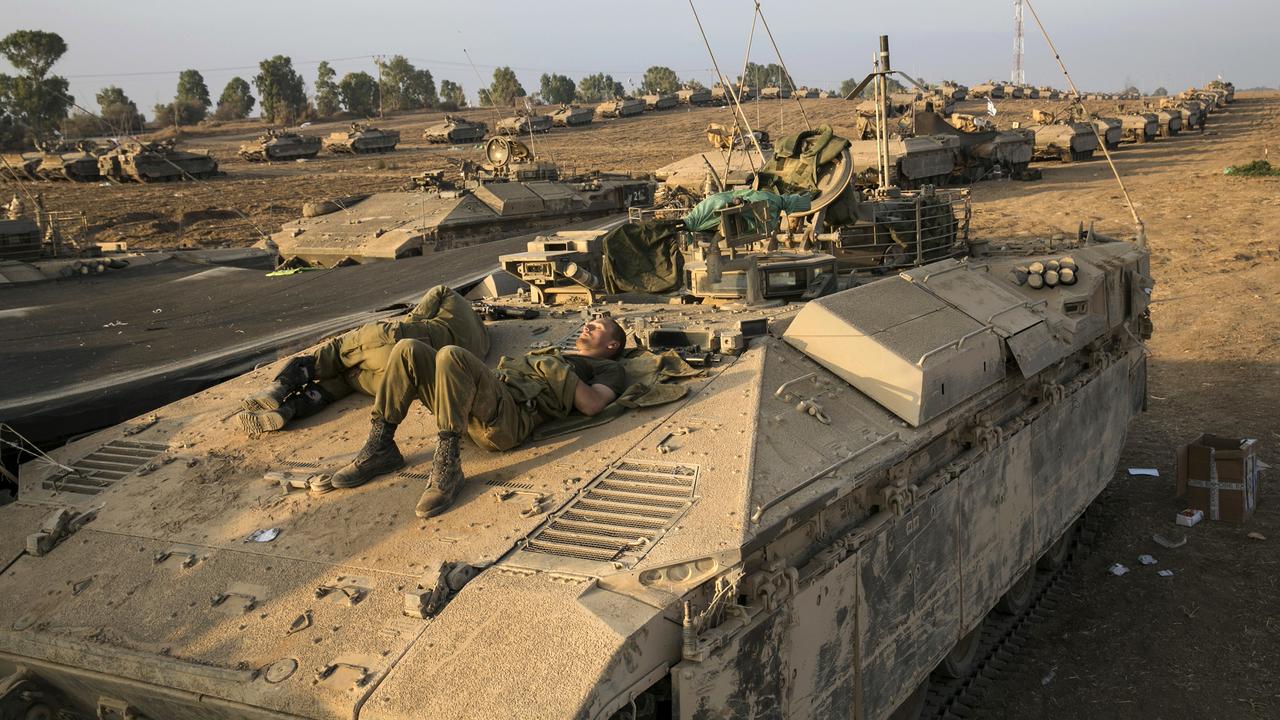 Des soldats israéliens se reposant sur un char ce lundi. [Baz Ratner]