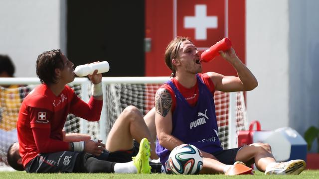 BRAZIL, Porto Seguro : Switzerland's goalkeeper Yann Sommer (L) and defender Michael Lang drink during a training session on June 16, 2014 at the Municipal Stadium in Porto Seguro, during the 2014 FIFA football World Cup in Brazil. AFP PHOTO / ANNE-CHRISTINE POUJOULAT [Anne-Christine Poujoulat]