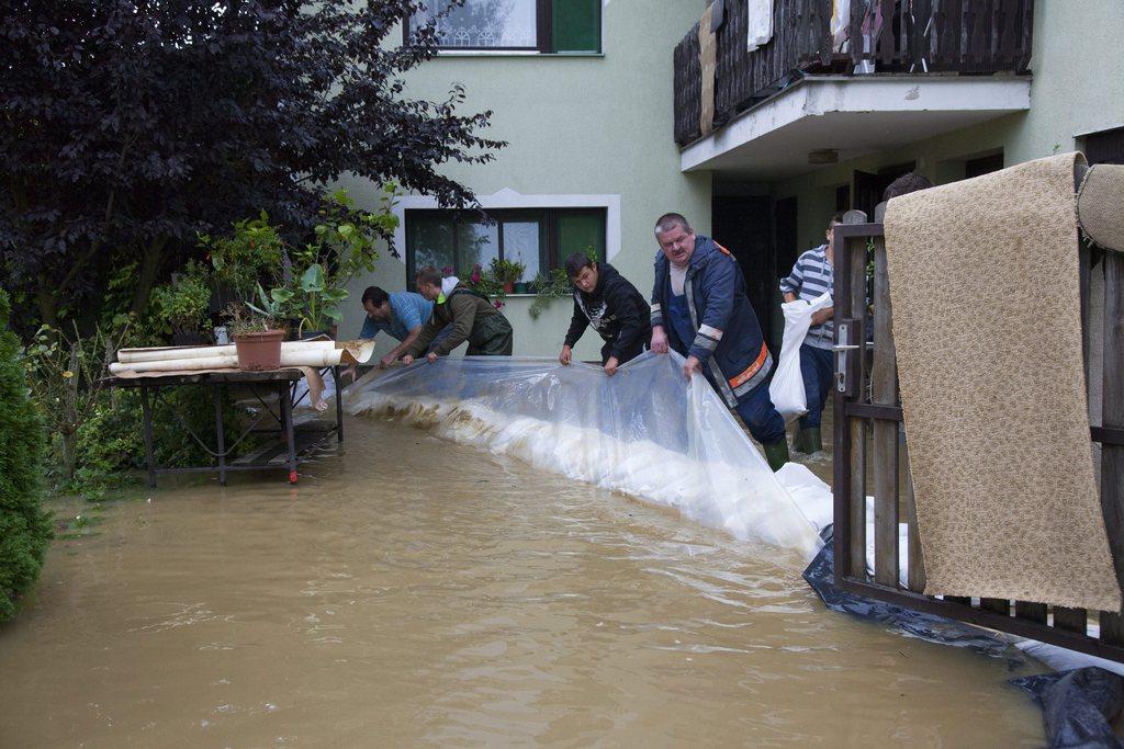 Des habitants tentent d'empêcher l'eau de pénétrer dans une maison de Csakanydoroszlo, au sud-ouest de Budapest, en Hongrie. [KEYSTONE - Gyorgy Varga]