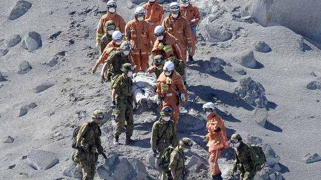 Des pompiers et secouristes transportent un blessé près du cratère du Mont Ontake. [Kyodo]