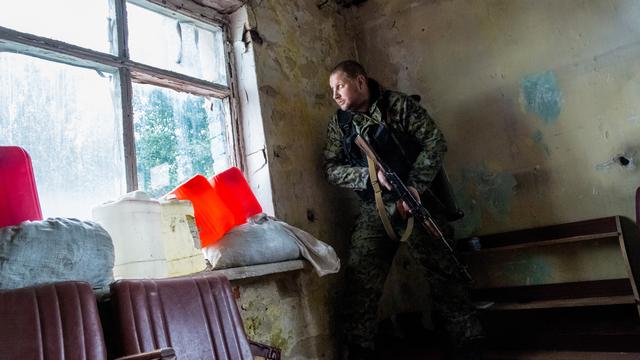 Un milicien séparatiste se cache lors d'une opération contre l'armée ukrainienne à Donetsk. [RIA Novosti - Andrey Stenin]