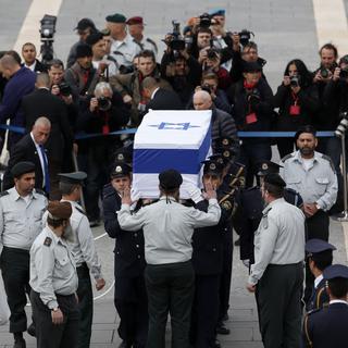 Des membres de la Knesset portent le cercueil d'Ariel Sharon devant le bâtiment du Parlement israélien. [Darren Whiteside]
