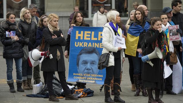 Une centaine de personnes ont demandé mercredi à Berne notamment de contrôler l'origine des fonds placés en Suisse par des Ukrainiens. [Peter Schneider]