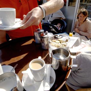 Un serveur, travailleur saisonnier apporte des café à des clients. Image d'archives. [Mychele Daniau]