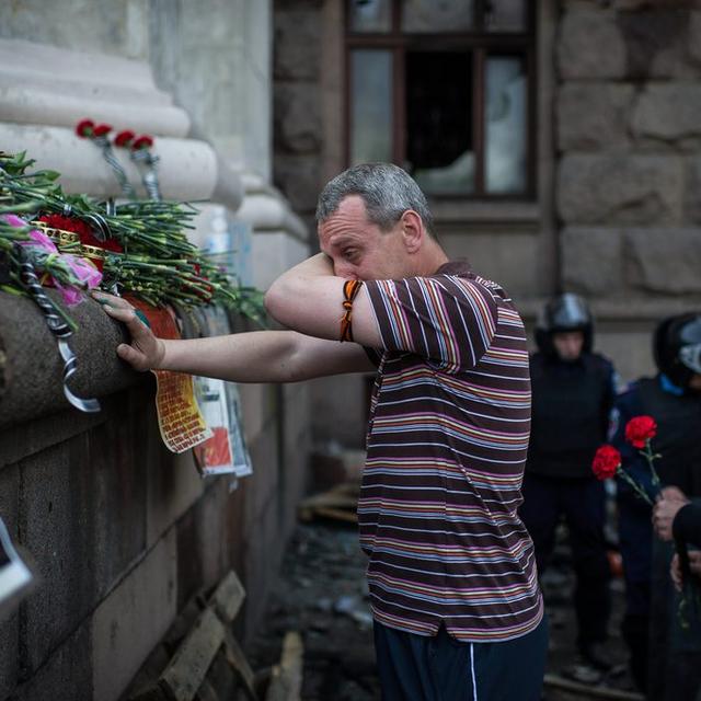 Un homme pleure après avoir déposé une fleur près du bâtiment incendié à Odessa le vendredi 2 mai et dans lequel une trentaine de militants pro-russes ont péri. [EPA/ALEXEY FURMAN]