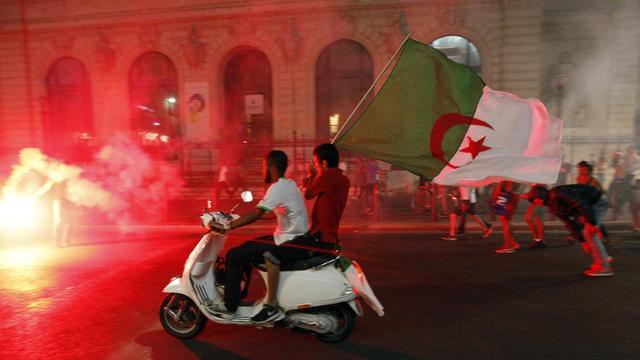 Des supporters algériens fêtent la qualification de leur équipe nationale pour les huitièmes de finale de la Coupe du monde à Marseille. [AP Photo/Claude Paris]