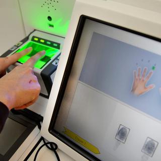 Le centre de recherche et d'évaluation créé à Martigny vise à la transmission des savoirs en matière de biométrie (ici la saisie de données biométriques à Lausanne, pour la réalisation d'un passeport). [Keystone - Dominic Favre]
