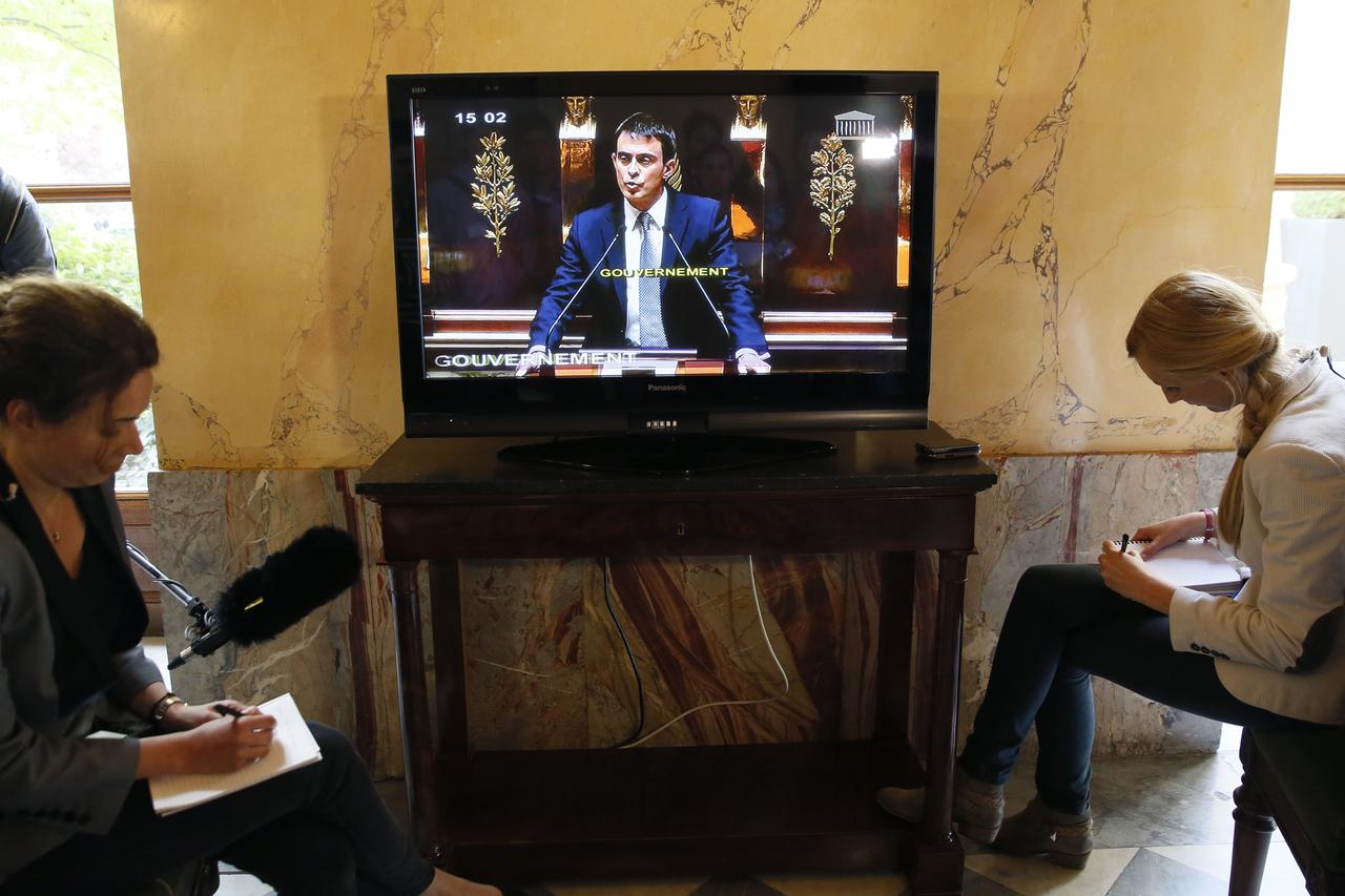 Des journalistes devant la retransmission du discours de politique générale de Manuel Valls, mardi 8 avril à l'Assemblée nationale. [Patrick Kovarik]