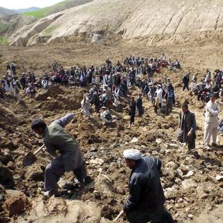 Des villageois afghans recherchant des survivants après le glissement de terrain qui a totalement enseveli un village. [Muhammad Sharif - EPA]