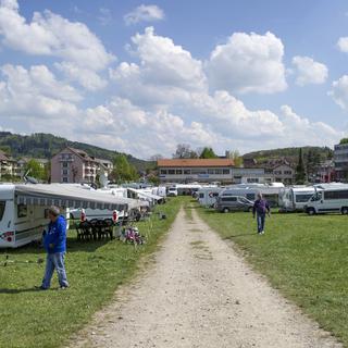 Un campement de gens du voyage s'est installé mercredi dans le quartier du Wankdorf à Berne pour protester contre le manque d'aires d'accueil en Suisse. [Keystone - Gian Ehrenzeller]