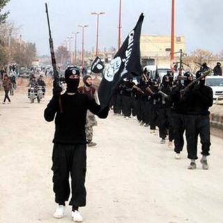 Cette image capturée sur un site internet de militants, montre des combattants de l'EIIL défilant dans leur quartier général de Raqqa, en Syrie. [AP Photo/site militant/Keystone]