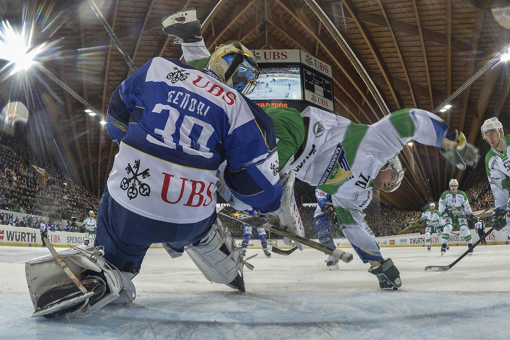 Le portier davosien Genoni à la lutte avec l'attaquant d'Ufa Hartikainen. [KEYSTONE - Peter Schneider]