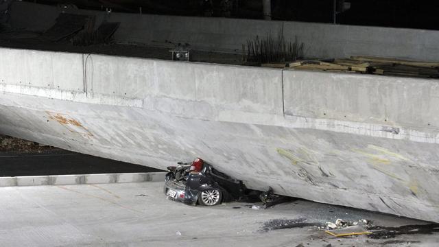 Une voiture littéralement écrasée par la chute de la bretelle d'autoroute. [EPA/Paulo Fonseca]