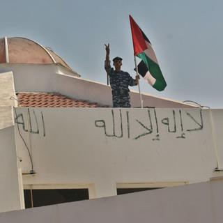 MIDDLE EAST; PALESTINIAN; JEWISH SETTLEMENT; HORIZONTAL; FLAG; ROOF; POLICE OFFICER; SYNAGOGUE; RELIGIOUS BUILDING; VICTORY SIGN; EXTERIOR VIEW [AFP - MOHAMMED ABED]