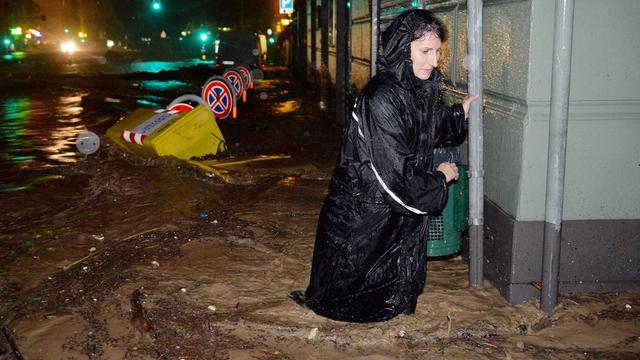 Une habitante de Gênes tente d'avancer dans une rue inondée, ce vendredi 10 octobre 2014. [LUCA ZENNARO]