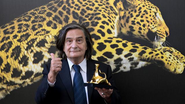 L'acteur français Jean-Pierre Léaud pose devant le fameux léopard du festival après avoir reçu le pirx "Pardo alla carriera". [AP Photo/Keystone, Urs Flueeler]