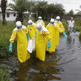 Une équipe de soignants au Liberia évacuent une victime du virus Ebola. [Ahmed Jallanzo]