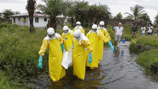 Une équipe de soignants au Liberia évacuent une victime du virus Ebola. [Ahmed Jallanzo]