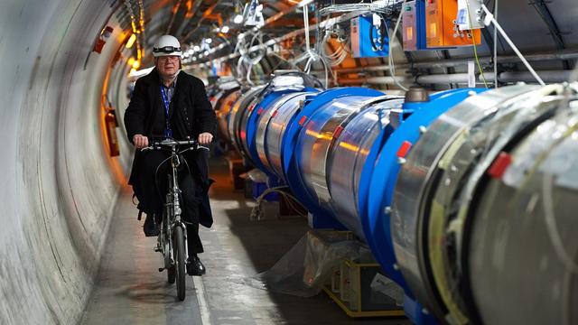 Le chercheur polonais Andrzej Siemko se déplace à bicyclette le long du LHC en novembre 2013. [EPA/ADAM WARZAWA]