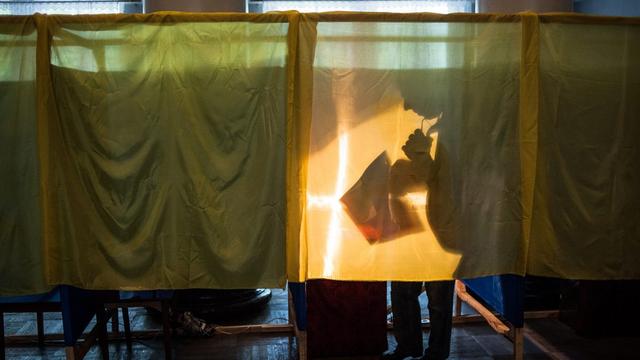 Un Ukrainien déposant son vote à Dobropillia, près de Donetsk. [Roman Pilipey - EPA]
