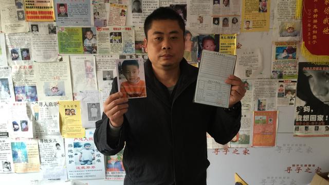 Xiao Chaohua tenant dans ses mains les papiers d'identité de son fils enlevé en 2005. [RTS - DONG Cao]
