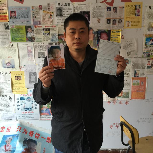 Xiao Chaohua tenant dans ses mains les papiers d'identité de son fils enlevé en 2005. [RTS - DONG Cao]