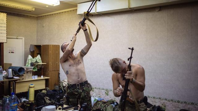 Des soldats ukrainiens du "bataillon Dombass" préparant leurs armes dans le camp de Popasnaya. [Roman Pilipey]