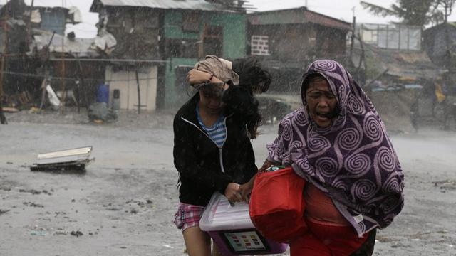 Des habitantes fuient les vents à Las Pinas, au sud de Manille. [EPA/FRANCIS R. MALASIG]