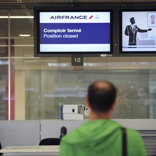 Un passager devant un comptoir vide à l'aéroport parisien d'Orly, au huitième jour de grève, ce lundi 22 septembre 2014. [AFP - STEPHANE DE SAKUTIN]