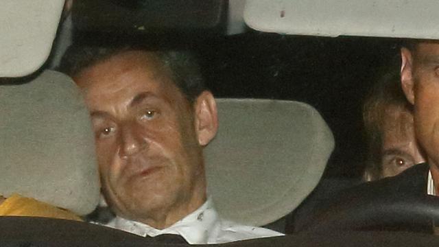 Nicolas Sarkozy arrive en fin de soirée avec des policiers au pôle financier du tribunal de Paris. [Pascal Rossignol]