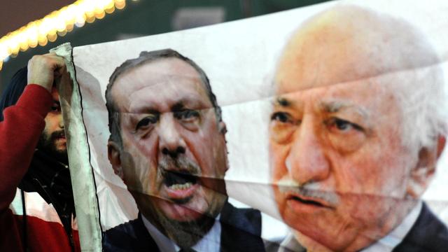 Une bannière portée par un opposant turc montrant le président Erdogan (à gauche) et le prédicateur musulman Fethullah Gülen. [OZAN KOSE]