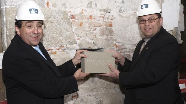 Pascal Broulis, conseiller d'Etat vaudois (à g.), et Laurent Wehrli, président du Grand Conseil vaudois (à dr.),  scellent sous un moellon plusieurs documents symboliques. [Salvatore Di Nolfi]