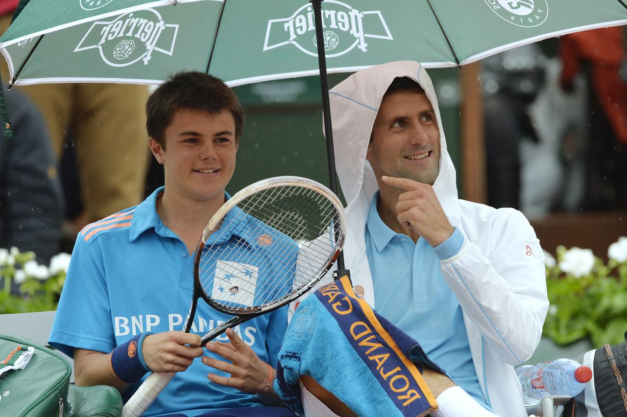 Djokovic n'a pas hésité à sympathiser avec un ramasseur de balle durant une interruption. [AFP - Miguel Medina]