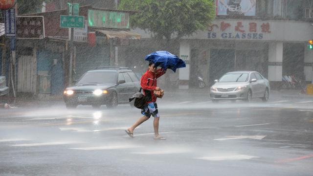 Un homme marche sous une pluie diluvienne à Taipei mercredi 23 juillet. [Sam Yeh]