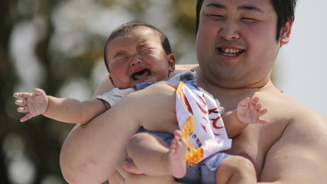 Samedi 26 avril: un sumo tient un bébé qui a participé à un concours de cris de bébés dans le temps de Senso-Ji à Tokyo, une cérémonie rituelle de prières pour qu'ils grandissent sans être malades. [AP Photo/Eugene Hoshiko]