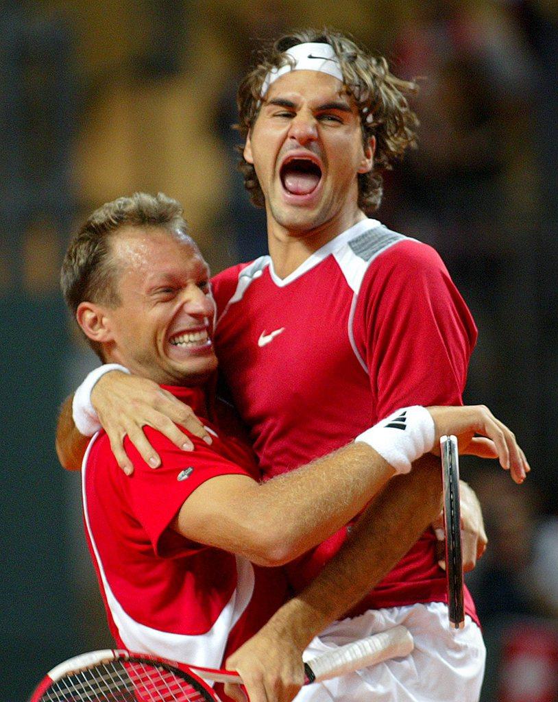 Septembre 2005: Allegro et Federer fêtent leur victoire en double contre la Grande-Bretagne à Genève. [KEYSTONE - Fabrice Coffrini]