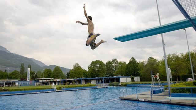 Andre se jette a l'eau dans la piscine lors de l'ouverture de la saison estivale ce samedi 2 mai 2009 a Monthey. (KEYSTONE/Jean-Christophe Bott) [Jean-Christophe Bott]