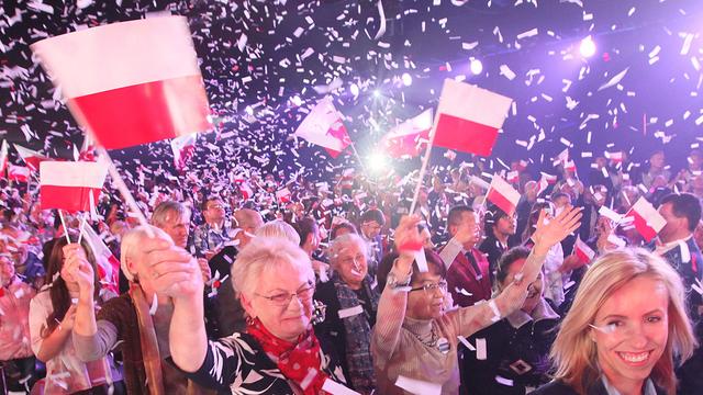 Des Polonais apportant leur soutien au parti populiste Droit et Justice. [Keystone - Czarek Sokolowsk - AP Photo]