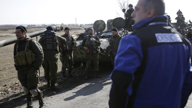 Des observateurs de l'OSCE devant des armes ukrainiennes à Donetsk, le 27 février 2015.